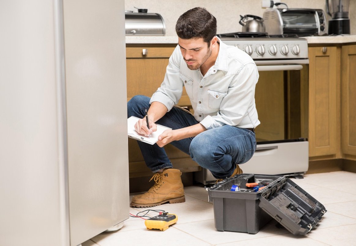Técnico da Refrigeração Cunha realizando diagnóstico em cozinha